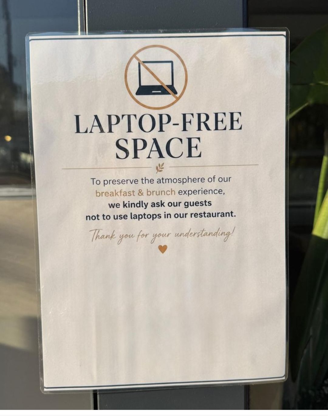 Schild an einer Restauranttür: „LAPTOP-FREE SPACE“ – die Gäste werden gebeten, beim Frühstück und Brunch keine Laptops zu benutzen.